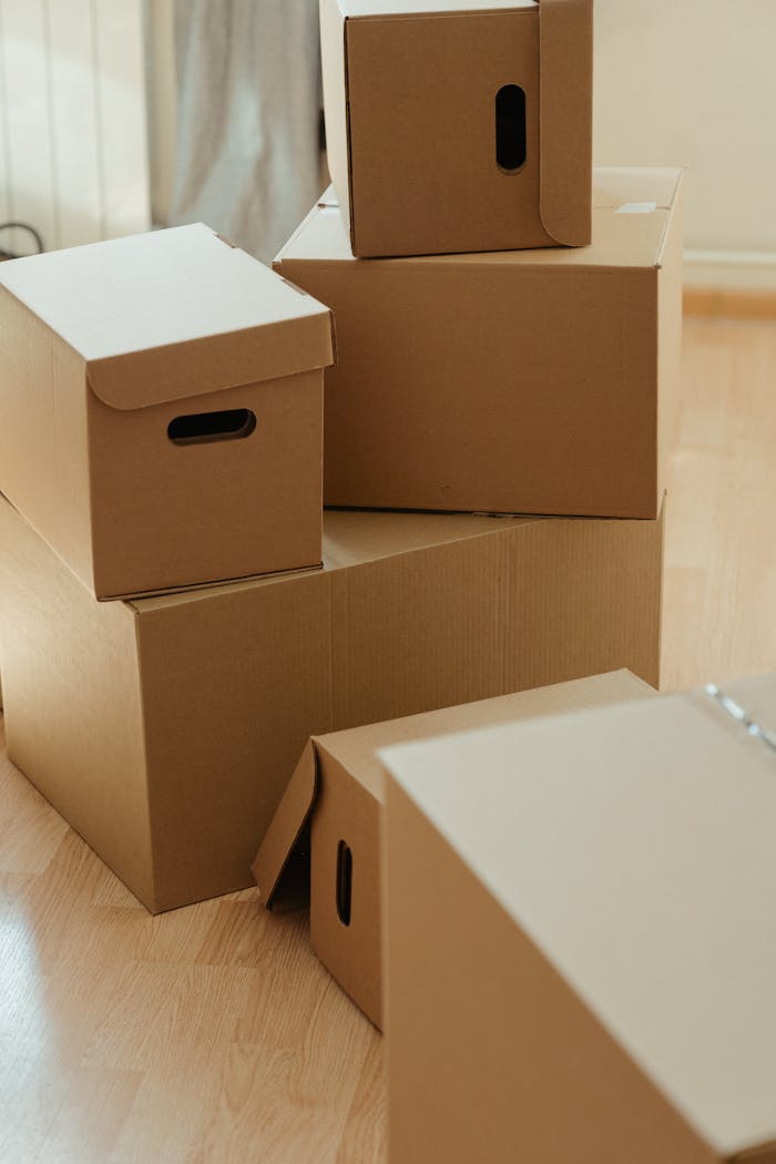 stats-img Cardboard boxes stacked on a wooden floor, symbolizing moving and new beginnings.